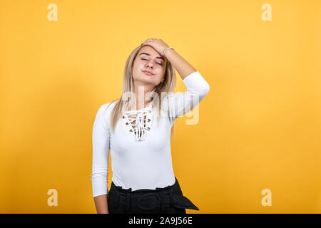 Jeune femme détendue dans les tenues de garder les yeux fermés, avec la main derrière la tête Banque D'Images