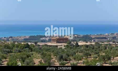 Vue sur la Vallée des Temples à Agrigente, en Sicile, avec le Temple de la Concorde au centre, la mer en arrière-plan et les arbres en premier plan Banque D'Images