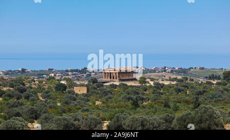 Vue sur la Vallée des Temples à Agrigente, en Sicile, avec le Temple de la Concorde au centre, la mer en arrière-plan et les arbres en premier plan Banque D'Images