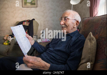 John Jenkins se lit une carte d'anniversaire de l'Hampshire et l'île de Wight Air Ambulance la charité dans sa maison, à Portsmouth, en avance sur son 100e anniversaire. Le vétéran du jour, qui a participé à une mission de reconnaissance secrète pour découvrir les plages de Normandie pour les forces alliées de l'avant du débarquement de juin 1944, célèbre son 100e anniversaire. Banque D'Images