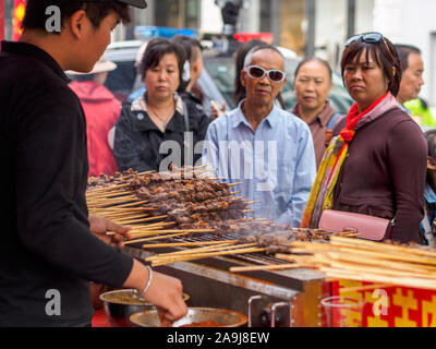 TIANJIN, CHINE - 6 OCT 2019 - Les clients attendent pour leur commande de brochettes d'agneau grillées style du Xinjiang dans un éventaire routier food. Brochettes d'agneau sont d'une popul Banque D'Images