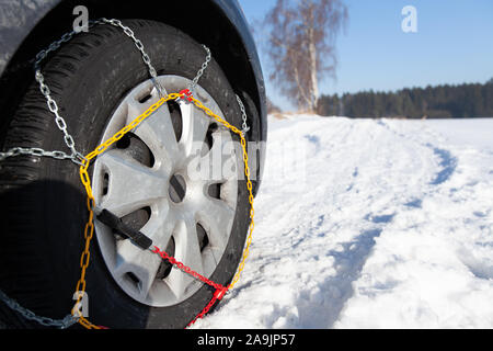 Voiture coincé dans la neige. Pneu équipé avec des chaînes à neige. Banque D'Images