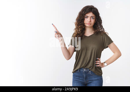 Pas impressionné les jeunes femme arménienne arrogant avec les cheveux bouclés froncer faisant coin supérieur gauche se demande avec mépris l'article express hésitante disbel Banque D'Images