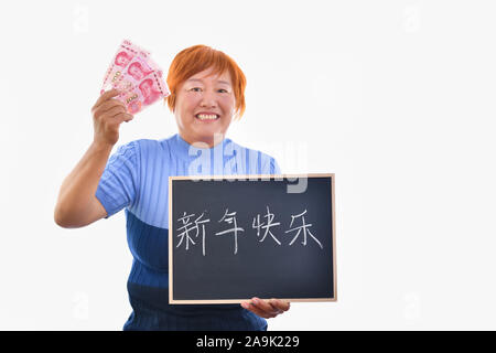 Smiling asian woman holding un tableau noir avec des symboles chinois et tenant à la main de yuan billets. Isolé sur fond clair. Le nouvel an chinois c Banque D'Images