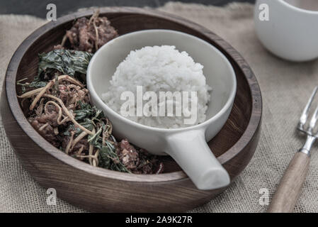 La nourriture épicée thaï épicé, profond Sautées Filet de poisson aux Herbes Légumes servi avec du riz vapeur à bol en bois : dans la langue thaï appelé 'Pad Cha ' Banque D'Images