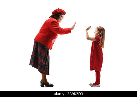 Profil de pleine longueur de balle faisant des gestes d'une femme âgée, cinq de haut avec une petite fille isolée sur fond blanc Banque D'Images