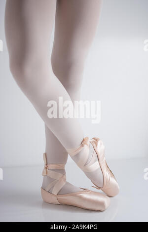 Détail des jambes et des pieds avec des chaussons de satin rose par un danseur classique posing Banque D'Images