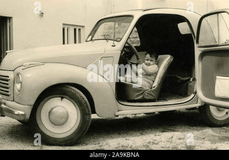 Enfant au volant d'une voiture Fiat Topolino, Italie Banque D'Images