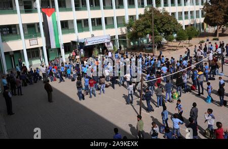 Deir Al-Balah, la bande de Gaza, territoire palestinien. 15 Nov, 2019. Des étudiants palestiniens détiennent des photos de membres de Al Sawarka famille qui ont été tués par une frappe aérienne israélienne a frappé, dans leur école, à Deir al-Balah, dans le centre de la bande de Gaza le 16 novembre 2019. Israël a dit qu'il visait la famille Al Sawarka et tué 8 personnes par erreur. Les groupes de défense des droits de l'armée israélienne ont critiqué les enquêtes sur les crimes de guerre commis dans la bande de Gaza : Crédit Ashraf Amra/APA/Images/fil ZUMA Alamy Live News Banque D'Images