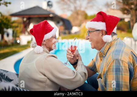 Happy senior couple in Santa hats profiter sur l'ensemble de vacances de Noël Banque D'Images