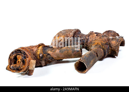 Des fragments de vieux tuyaux d'eau en fonte sur fond blanc. Après de nombreuses années de fonctionnement du tuyau de métal corrodé a été détruit. Tube acier rouillé avec hol Banque D'Images