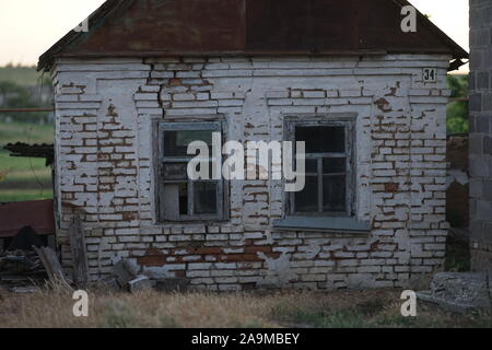 Façade d'une vieille maison rurale avec deux fenêtres. Bâtiment abandonné. Banque D'Images