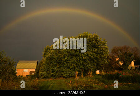 Grand arc-en-ciel sur une ferme dans le pays au cours de l'été, avec un matin soleil et nuages d'orage lointain, In Browntown, Wisconsin, États-Unis Banque D'Images