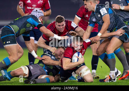 Swansea, Royaume-Uni. 16 novembre, 2019. Munster lock Jean Kleyn est abordée dans les Ospreys v Munster Heineken Cup Rugby Match des Champions. Credit : Gruffydd Ll. Thomas/Alamy Live News Banque D'Images