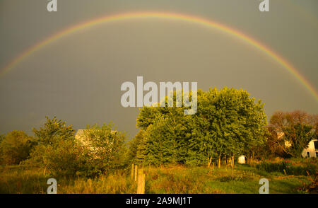 Grand arc-en-ciel sur une ferme dans le pays au cours de l'été, avec un matin soleil et nuages d'orage lointain, In Browntown, Wisconsin, États-Unis Banque D'Images