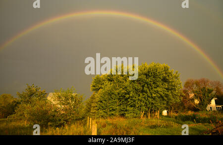 Grand arc-en-ciel sur une ferme dans le pays au cours de l'été, avec un matin soleil et nuages d'orage lointain, In Browntown, Wisconsin, États-Unis Banque D'Images