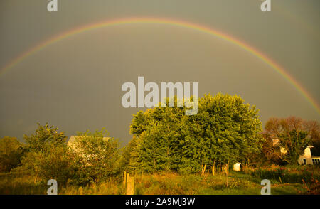 Grand arc-en-ciel sur une ferme dans le pays au cours de l'été, avec un matin soleil et nuages d'orage lointain, In Browntown, Wisconsin, États-Unis Banque D'Images