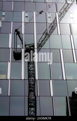 WA17326-00...WASHINGTON - grue de construction sur un immeuble en verre qui reflète à Seattle. Banque D'Images