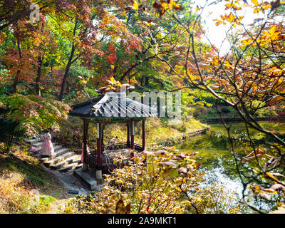 Séoul, Corée du Sud - 31 octobre 2019 : les filles dans Gwallamjeong sur pavillon en bois dans l'étang de jardin arrière Secret Huwon Palais Changdeokgung complexe dans Se Banque D'Images