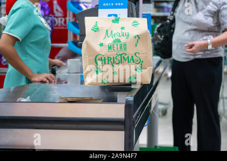 Une femme l'épicerie qui sont placés dans un sac en papier brun.mercredi et samedi sont des jours désignés pas de sac en plastique dans ce magasin en particulier dans Banque D'Images