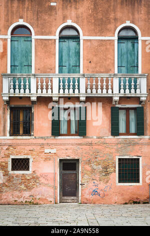 Venise, Italie - le 23 décembre 2012. Face d'une maison de ville ancienne avec des murs en détresse et de vieux volets en bois Banque D'Images