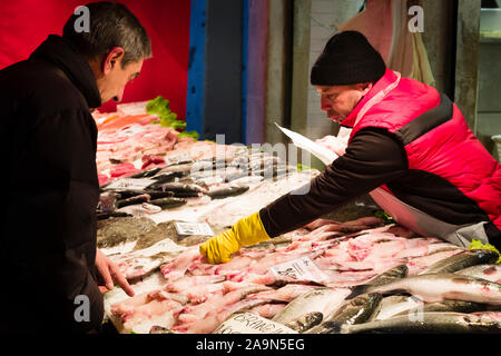 Venise, Italie - le 24 décembre 2012. Un client achète du poisson frais en début de matinée à un marché aux poissons Mercado de Rialto de Venise, Italie Banque D'Images