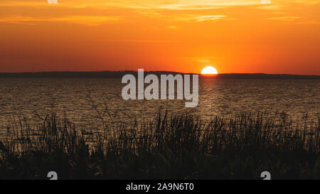 Coucher de soleil sur les collines au loin sur le lac Apopka à Apopka, en Floride. Banque D'Images