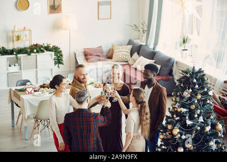Portrait de groupe d'élégant aux personnes bénéficiant d'une soirée de Noël et boire le champagne dans la belle salle à manger, copy space Banque D'Images