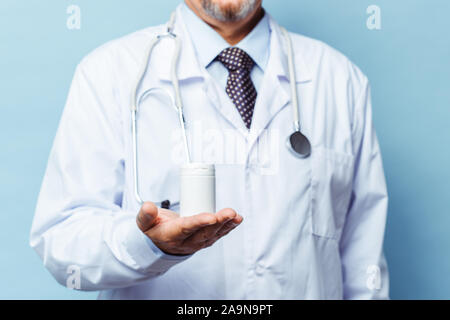 Doctor holding bouteille de pilules sur fond blanc. Le concept de la médecine, pharmacologie, santé Banque D'Images