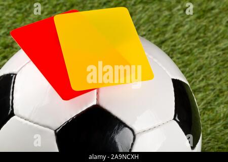 Close up of arbitre des cartons jaunes et rouges sur le dessus de jeu 3 ball sur fond d'herbe - pénalité, s'emmêler ou de sport concept, selective focus Banque D'Images