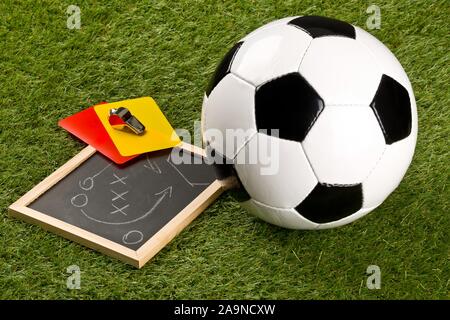 Sports Soccer ball et arbitre sifflet chrome avec stratégie de jeu dimensions tableau noir et jaune et rouge sur fond d'herbe cartes arbitre - f Banque D'Images