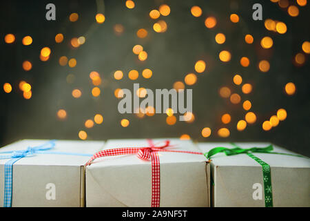 Pile de gift wrapped cadeaux de Noël. La pile de cadeaux est empilé soigneusement sur la table avec une guirlande en arrière-plan. Vue de côté. Banque D'Images