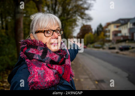 13 novembre 2019, en Rhénanie du Nord-Westphalie, Bielefeld : Rosa résident Rosinski se tient juste en face de sa maison le Schlosshofstraße à Bielefeld et des points situés en bas de la rue. Schlosshofstrasse est actuellement en cours de rénovation et les résidents s'en partager les coûts. Schlosshofstrasse est actuellement en cours de rénovation et les résidents s'en partager les coûts. Depuis la ville de Bielefeld classifie la rue comme une rue résidentielle, les contributions pour les propriétaires sera particulièrement élevé. (Dpa 'La pomme de discorde la contribution de la construction routière - retraités soucieux pour la sécurité') Pho Banque D'Images