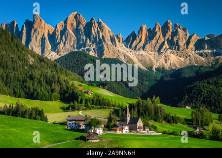 Alpine pittoresque village avec église et paysage de montagne. Randonnée populaire, touristique et lieu de photographie avec paysages étonnant à Val di Funes Banque D'Images