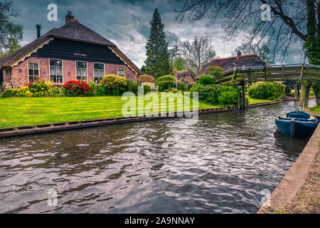 Village touristique bien connu avec des canaux d'eau. Maisons avec jardins ornementaux ordonnée dans le village de Giethoorn, Pays-Bas, Europe Banque D'Images