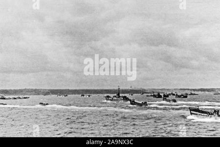 [CAPTION] l'origine des engins de débarquement d'Omaha Beach approche toutes tailles remplis de troupes d'assaut de la première vague à fouler le sol français. Normandie Juin 1944 Banque D'Images