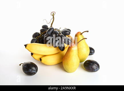 Nature morte avec les bananes, poires, prunes et raisins sur un fond blanc. Banque D'Images