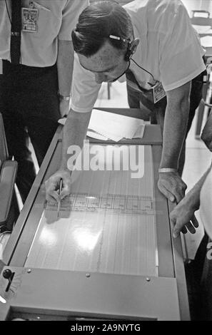 S69-39588 (20 juillet 1969) --- Dr. Garry Latham, avec l'Observatoire, études géologiques Lamont tracés dans le sismomètre Centre de contrôle de mission ?s de la salle de contrôle de l'ASEP. Les données électroniques a été provenant de l'ensemble des expériences sismiques passive qui les astronautes d'Apollo 11 avait déployé sur la surface de la lune. Banque D'Images