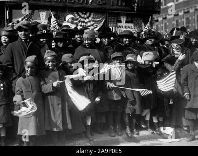 Photos de la PREMIÈRE GUERRE MONDIALE - de couleur / African American troupes - enfants de couleur se sont rassemblés le long de la ligne de mars de prolonger leurs daddies royal bienvenue à la 369e (ancien de 15e régiment de New York), comme la célèbre 5e Avenue des combattants jusqu'à la parade Bienvenue chez ca. 1918-1919 Banque D'Images