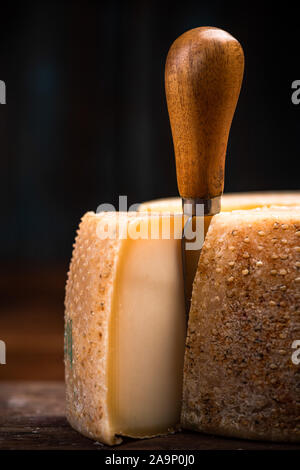 Meule de fromage dur mûri. La production alimentaire traditionnelle locale dans cours, cave. Banque D'Images