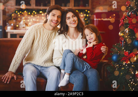 Friendly famille obtenir prêt pour Noël, sitting on sofa Banque D'Images