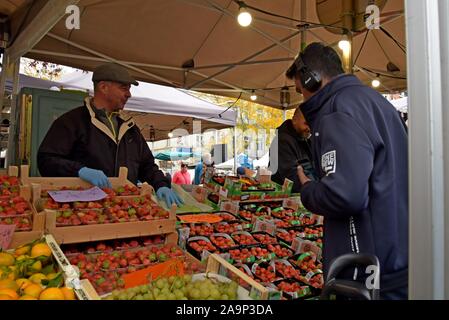 Les acheteurs de l'examen et de la sélection des fruits et légumes au marché du Midi, open air dimanche marché en dehors de la gare Bruxelles Midi Banque D'Images