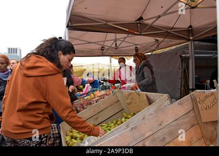 Les acheteurs de l'examen et de la sélection des fruits et légumes au marché du Midi, open air dimanche marché en dehors de la gare Bruxelles Midi Banque D'Images