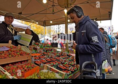 Les acheteurs de l'examen et de la sélection des fruits et légumes au marché du Midi, open air dimanche marché en dehors de la gare Bruxelles Midi Banque D'Images