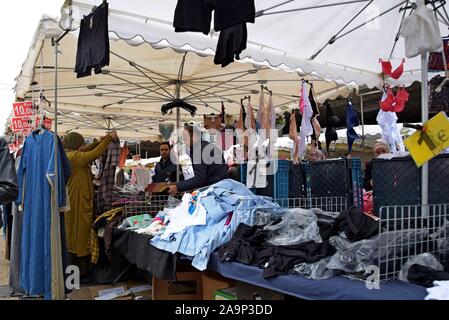 Vêtements femmes examinant en vente sur un stand lors de la Marche du Midi, open air dimanche marché en dehors de la gare Bruxelles Midi Banque D'Images