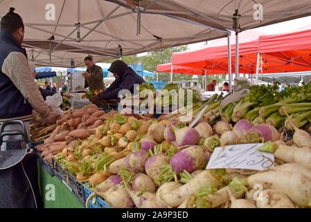 Les acheteurs de l'examen et de la sélection des fruits et légumes au marché du Midi, open air dimanche marché en dehors de la gare Bruxelles Midi Banque D'Images