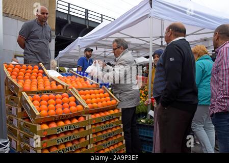 Les acheteurs de l'examen et de la sélection des fruits et légumes au marché du Midi, open air dimanche marché en dehors de la gare Bruxelles Midi Banque D'Images