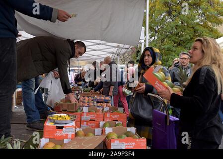 Les acheteurs de l'examen et de la sélection des fruits et légumes au marché du Midi, open air dimanche marché en dehors de la gare Bruxelles Midi Banque D'Images