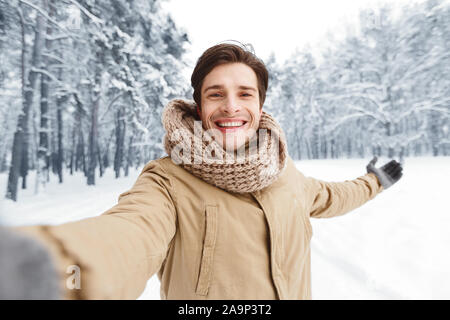 Homme heureux en tenant debout dans la forêt Hiver Selfies Banque D'Images