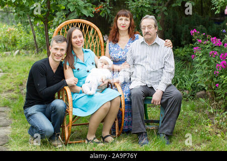 Portrait de famille dans le jardin. Grand-mère grand-père Papa maman et bébé Banque D'Images